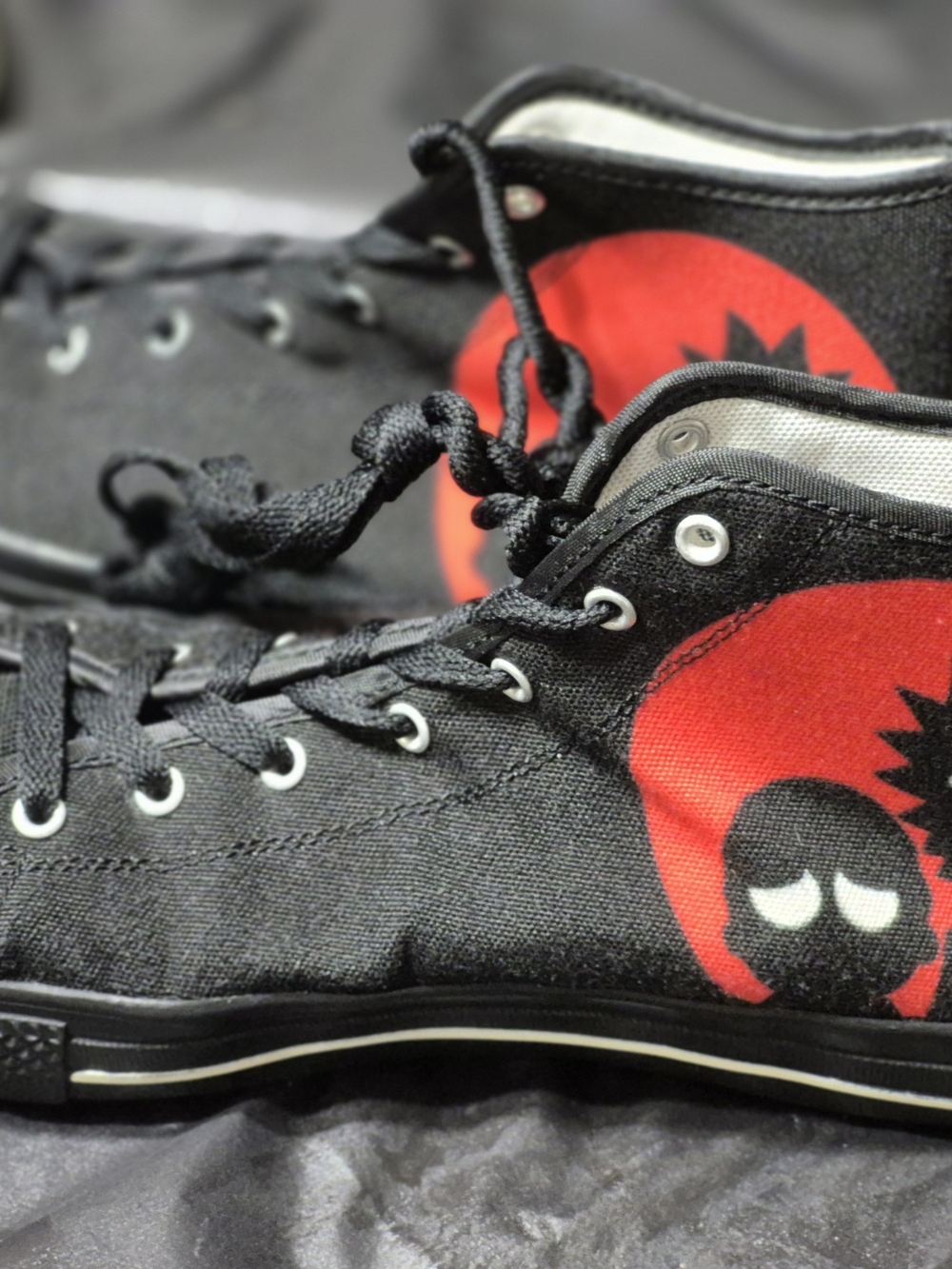 Stylish black high-top sneakers featuring a bold red cartoon graphic design. Lac